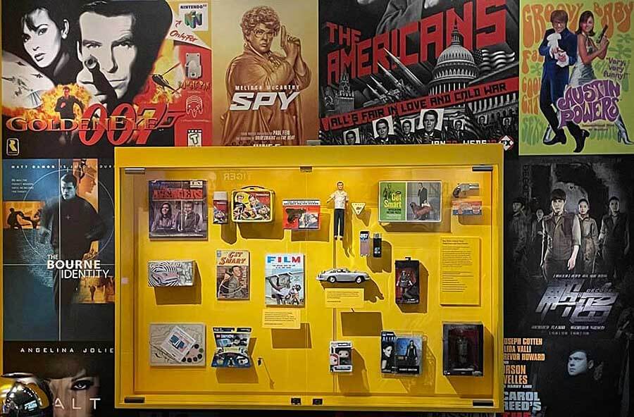 A wall covered with spy movie posters in the spy museum
